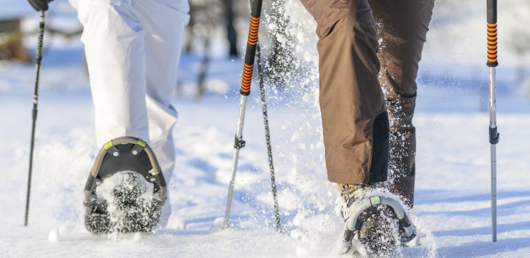 Due persone con camminano nella neve con le ciaspole